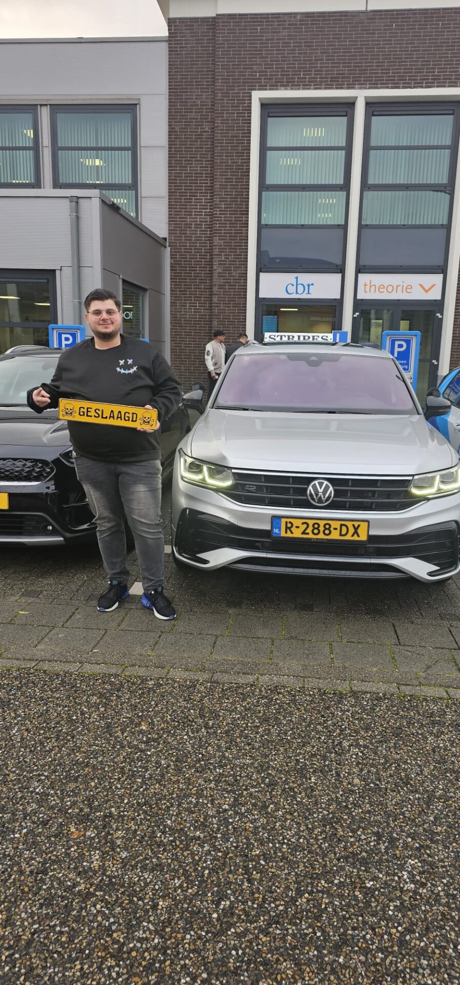 Leerling toont het geslaagd-bord bij de Volkswagen Tiguan automaat lesauto