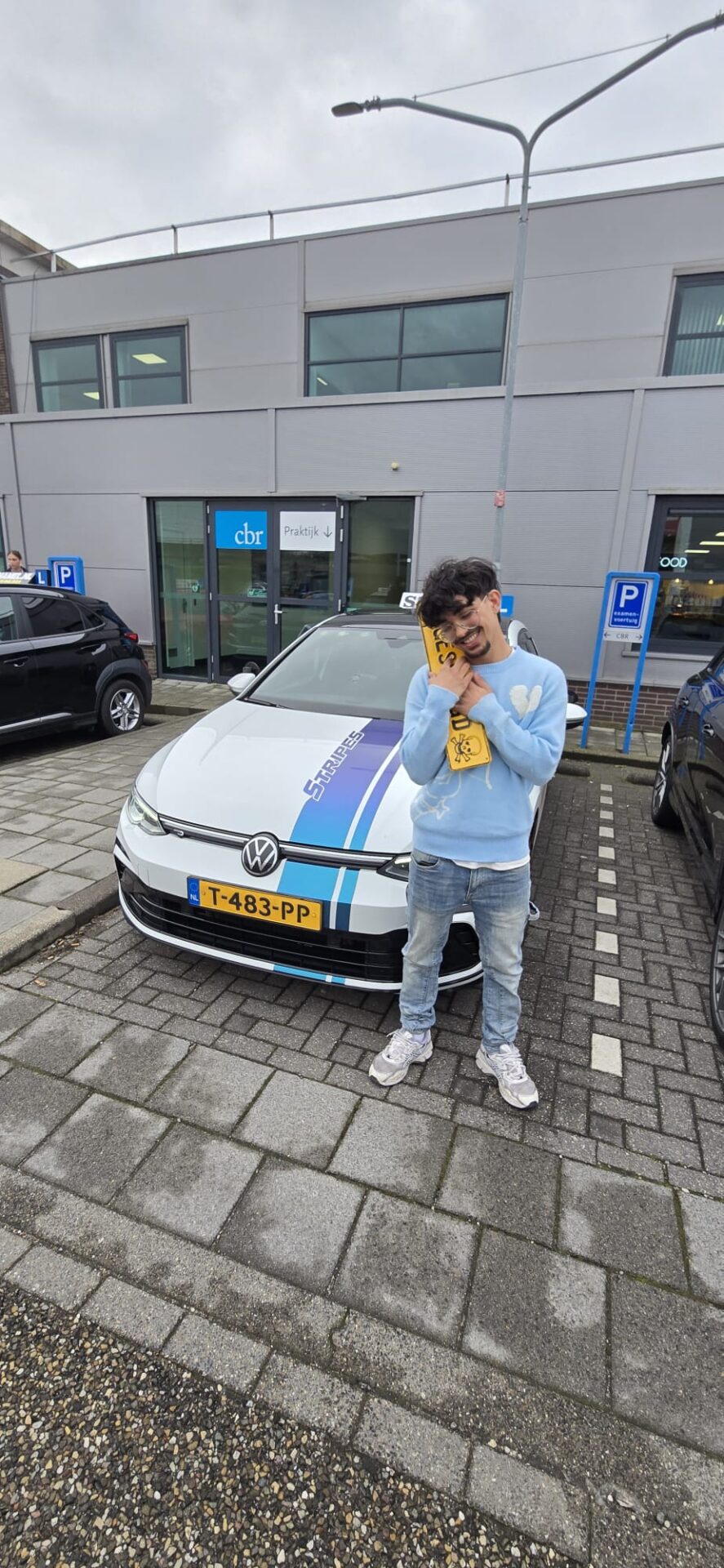 Leerling viert het behalen van het rijbewijs bij de schakelauto van Rijschool Stripes