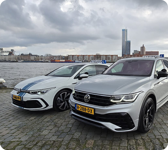 Automaat en schakel lesauto van Rijschool Stripes bij de Rotterdamse skyline